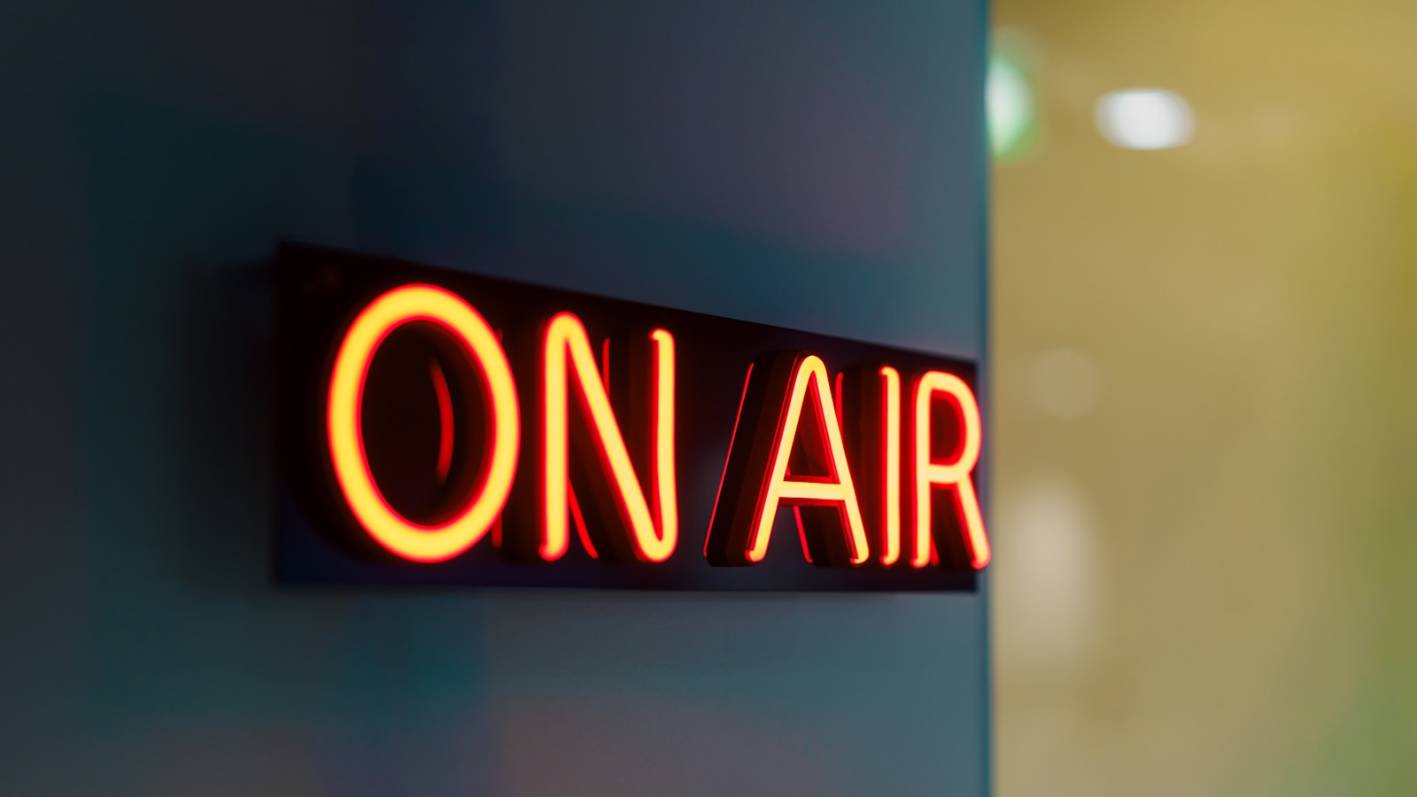 Illuminated on air sign glowing red outside a radio studio, the moment radio imaging goes to work selling the station