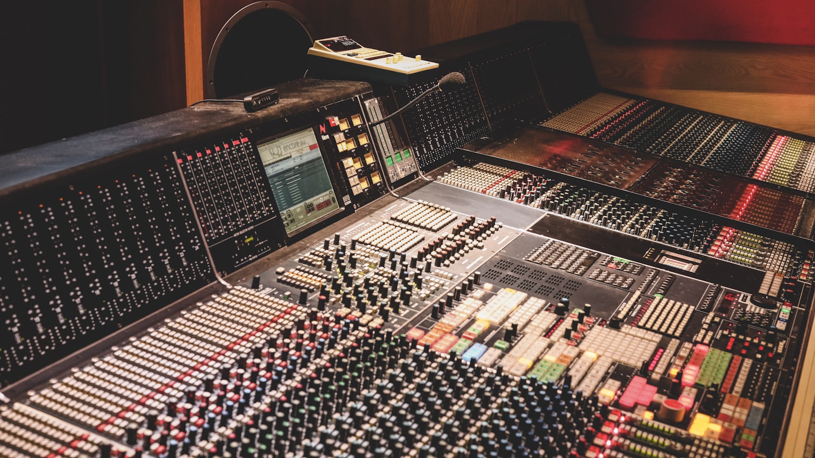 Large-format broadcast production console with faders and channel strips, the kind used to mix a radio station imaging package